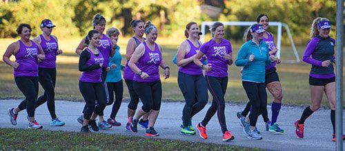 A group of 14 women running and wearing MOTR shirts