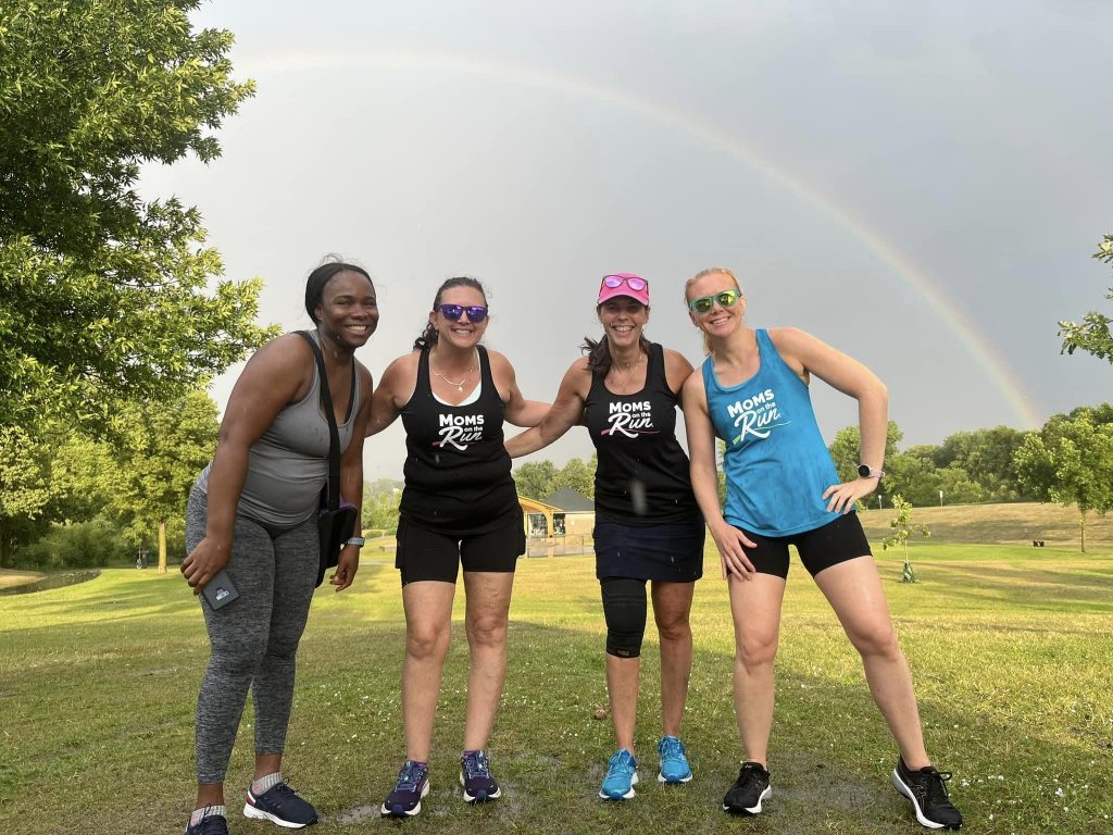Four Moms on the Run Members standing in front of a rainbow