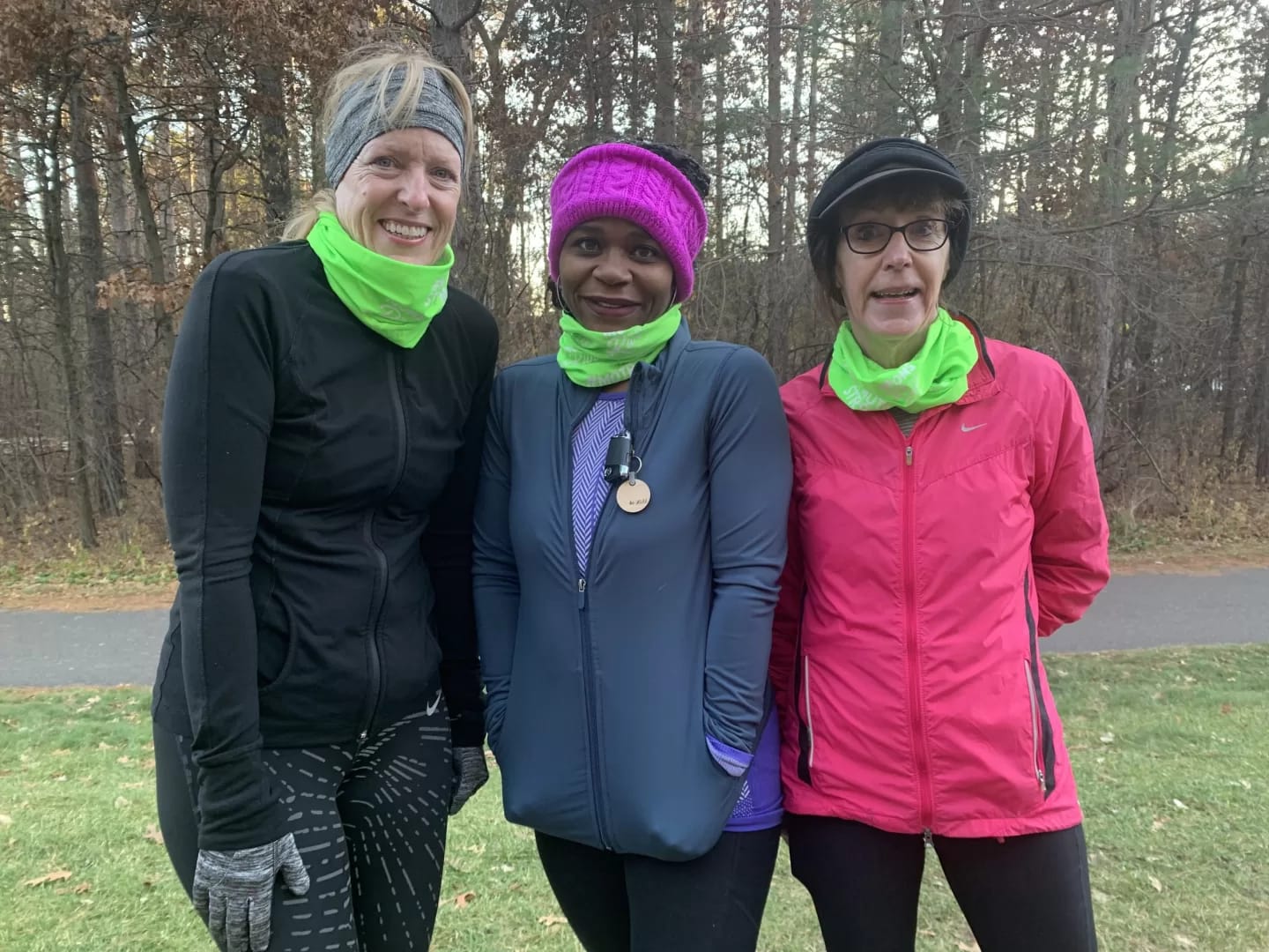 Three MOTRs stand in front of barren trees wearing matching Moms on the Run-branded scarves