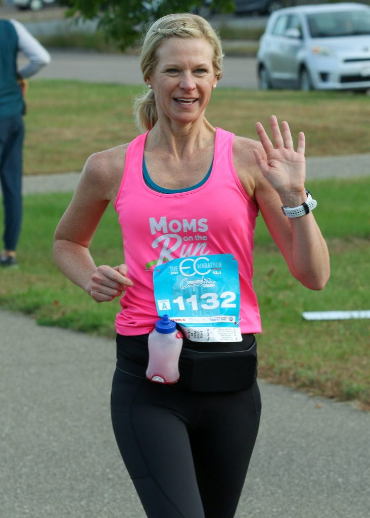 coach sarah from Eau Claire running the Eau Claire marathon and waving