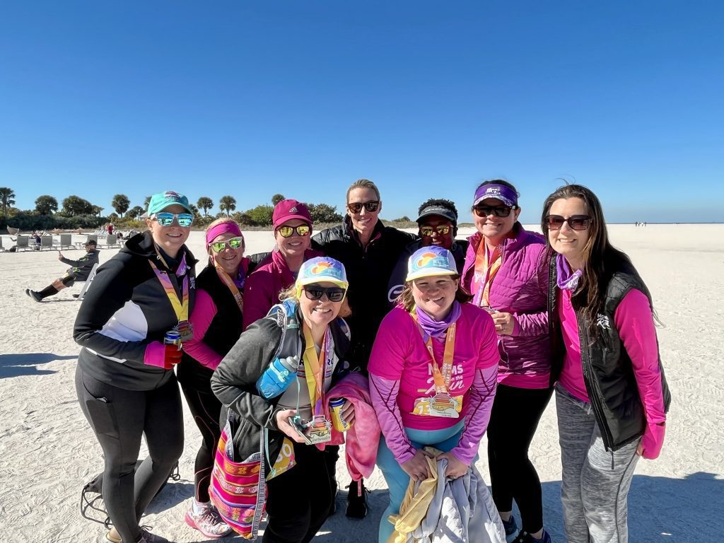 Group of MOTRs standing on beach at destination race wearing race medals
