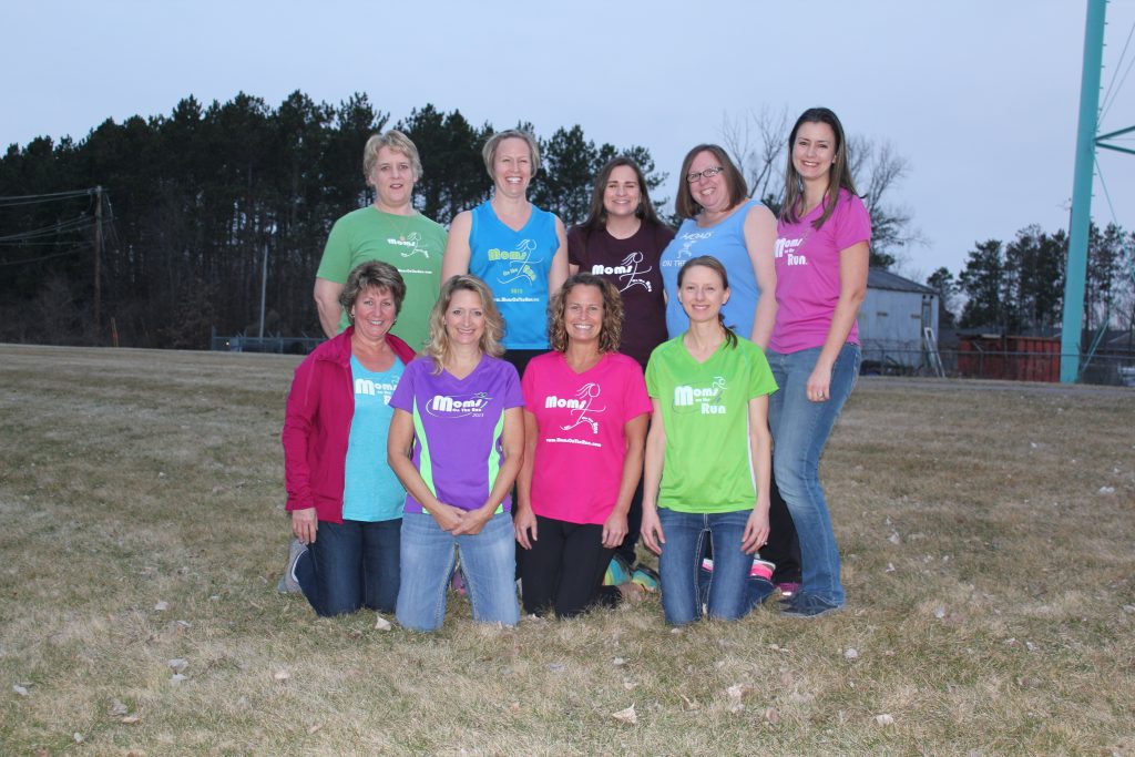 An older photo of women in different colored Moms on the Run shirts that depicts the story of Moms on the Run's beginnings.