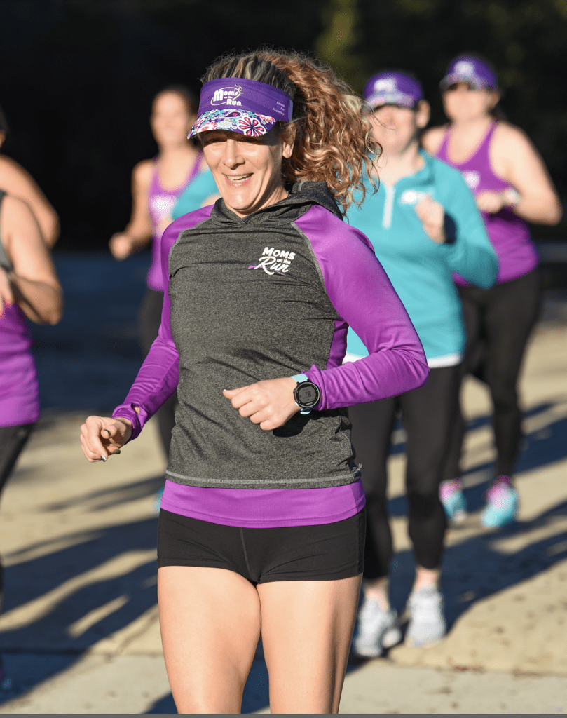 Amy, coach and owner of Jacksonville-Mandarin, Nocatee and St. Johns, running in the sun with a smile and Moms on the Run visor