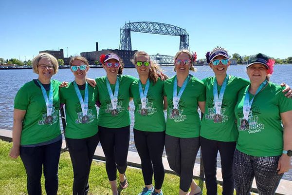 Burnsville Moms on the Run wearing race medals at Grandma's Marathon
