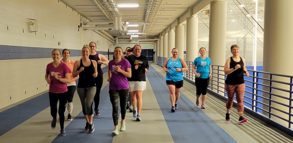 Moms on the Run running on an indoor track, likely running intervals