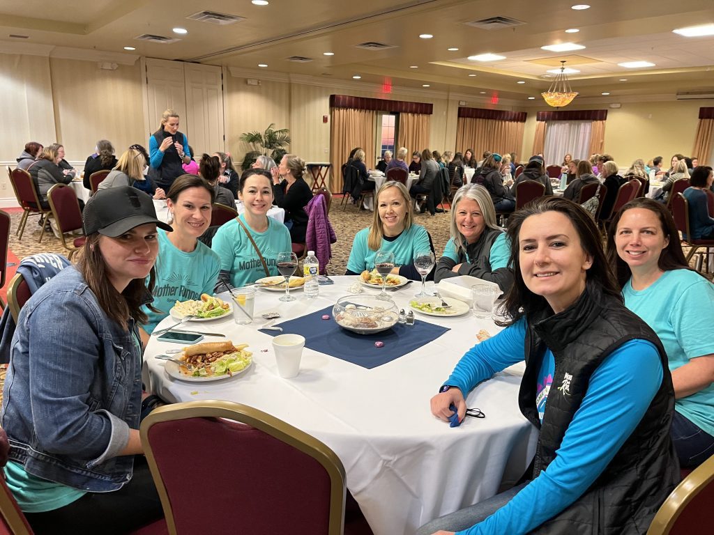 Founder and CEO Karissa sitting at a banquet table with MOTR members