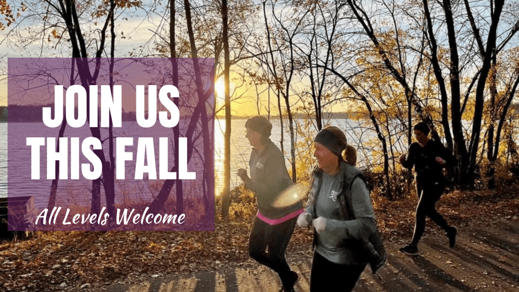 runners in woods in the fall at sunset