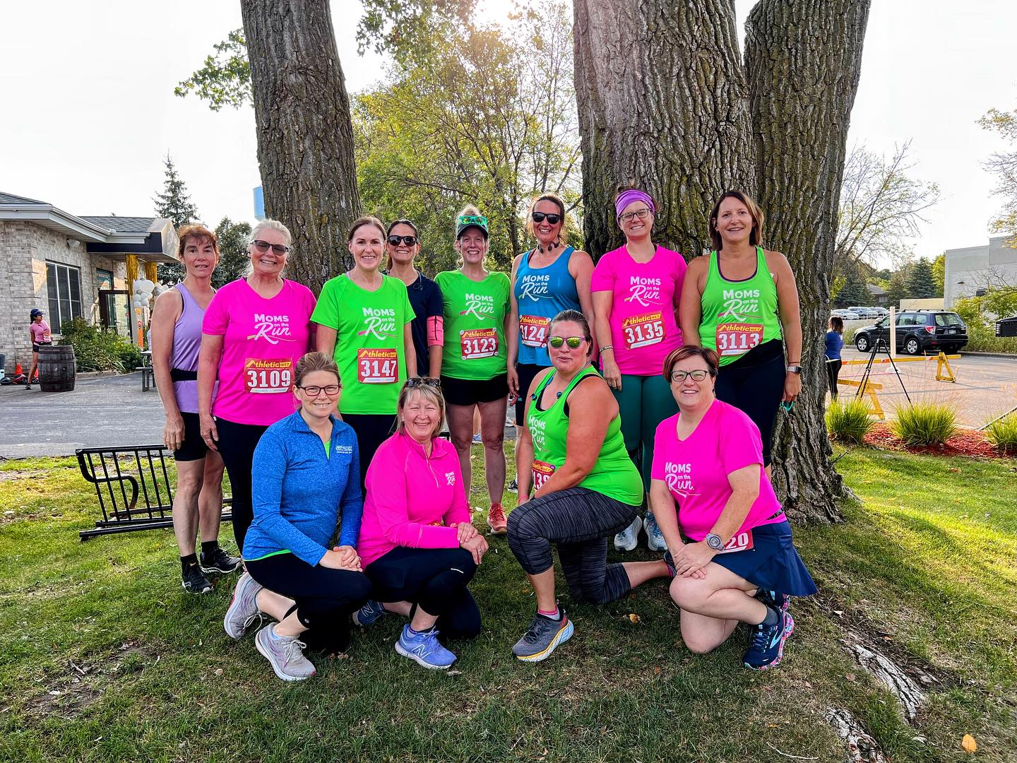 Moms on the Run from the Hudson-Stillwater area standing in front of a tree at the Liftbridge 5K