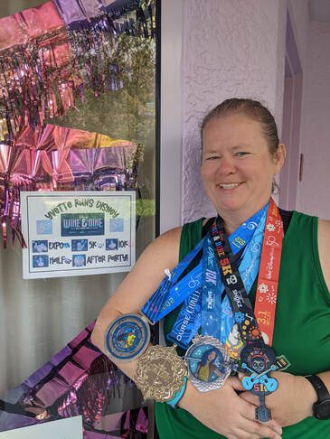 A MOTR member wearing medals for a 5K, 10K, and half marathon