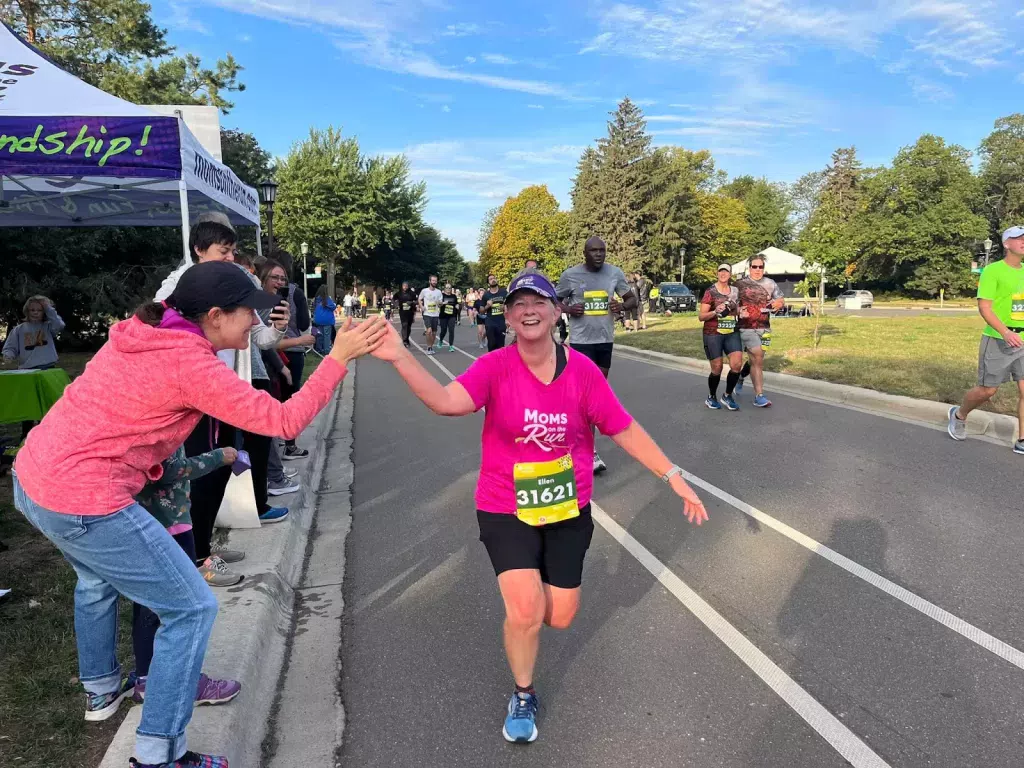 Ellen racing and giving a high-five to a spectator