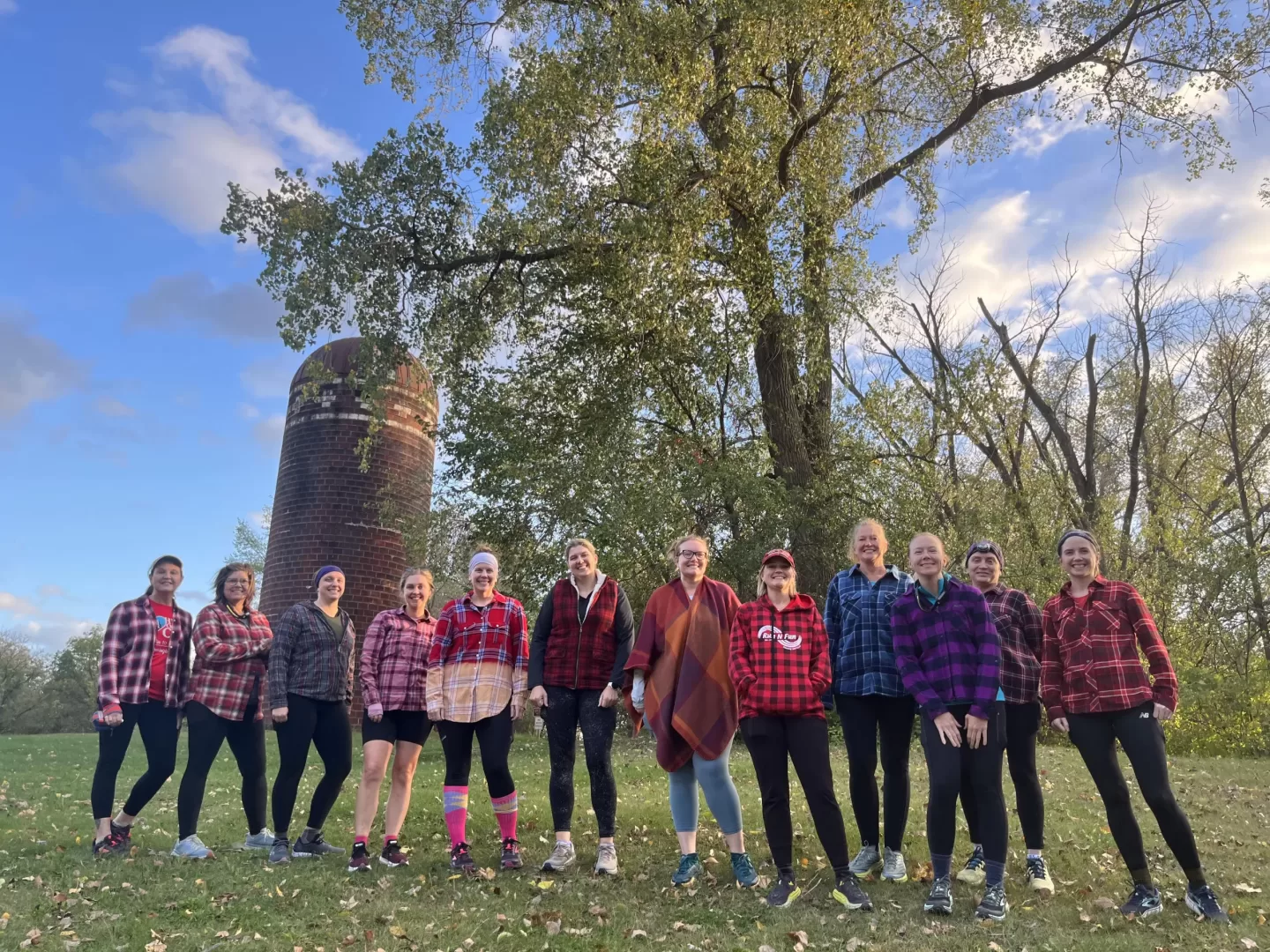 Runners in plaid in front of silo