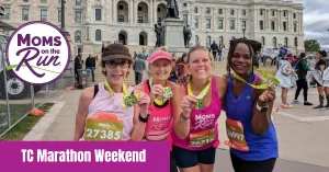 Female runners holding finisher's medal at capital