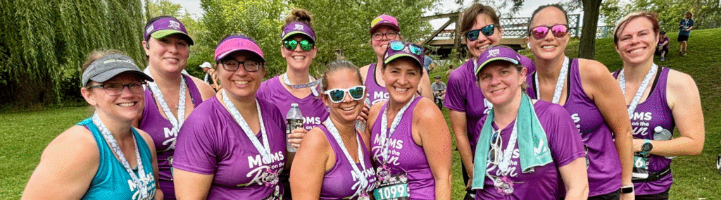 women runners in purple race shirts with medals