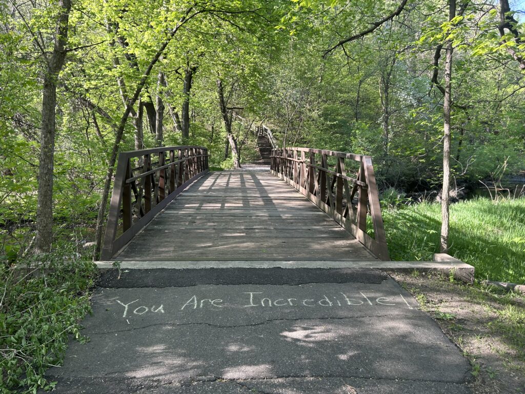 Running path with sidewalk chalk that says you are incredible