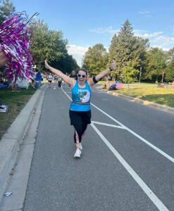 woman racing with her arms up
