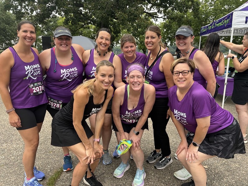 female runners in purple race shirts posing