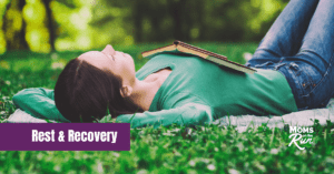 Woman lying down in grass with book on chest