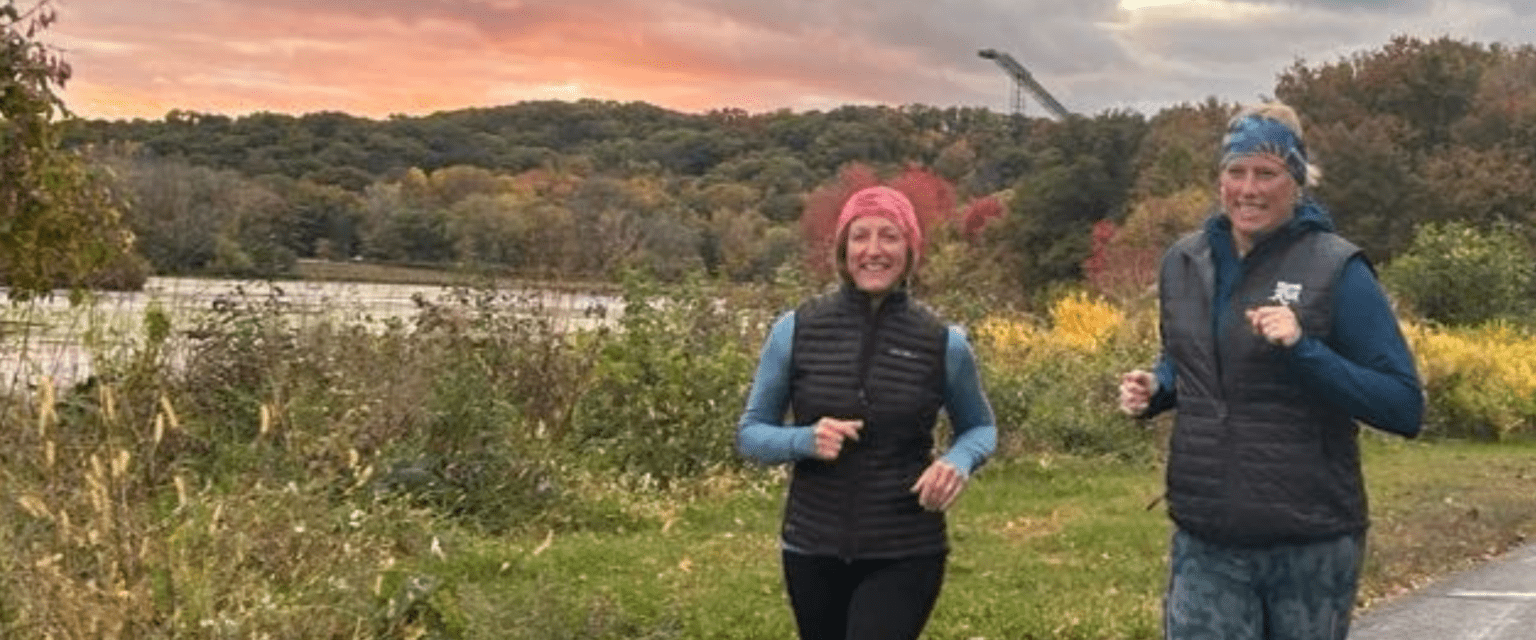 two women running with fall and sunset